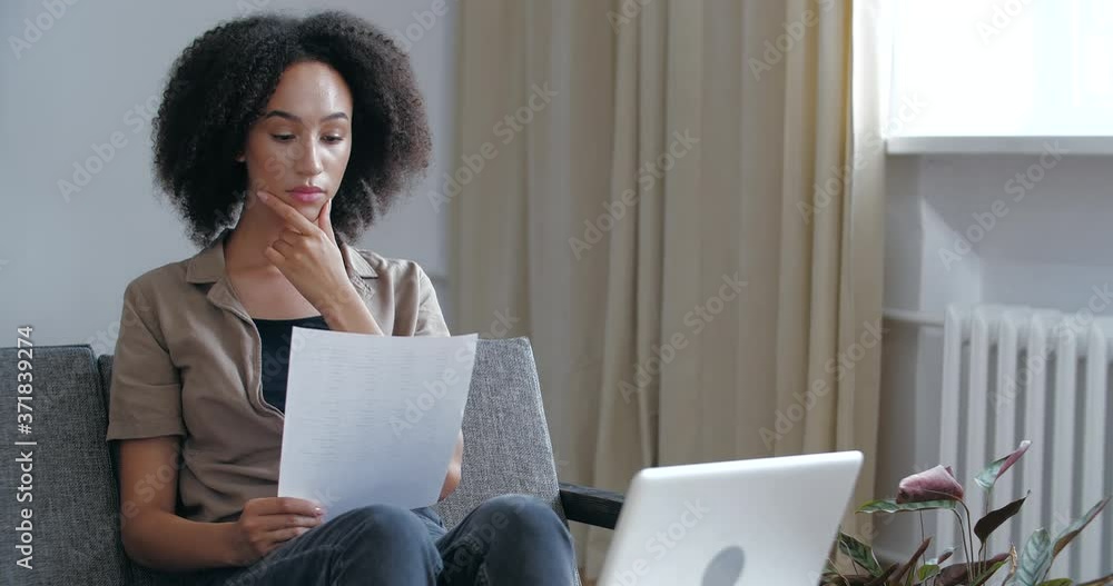 Young woried curly African girl receives letter in mail with bad news, medical tests, learns about failed exams, holds refusal notice in her hands, feels sad displeasure resentment, upset female face Young woried curly African girl receives letter in mail with bad news, medical tests, learns about failed exams, holds refusal notice in her hands, feels sad displeasure resentment, upset female face