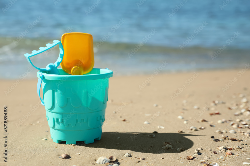 Different child plastic toys on sandy beach. Space for text Different child plastic toys on sandy beach. Space for text