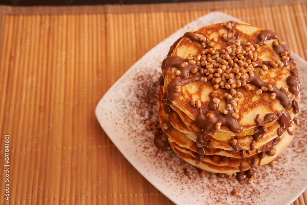 Delicious plate of pancakes with peanut syrup, cocoa and toppings Delicious plate of pancakes with peanut syrup, cocoa and toppings
