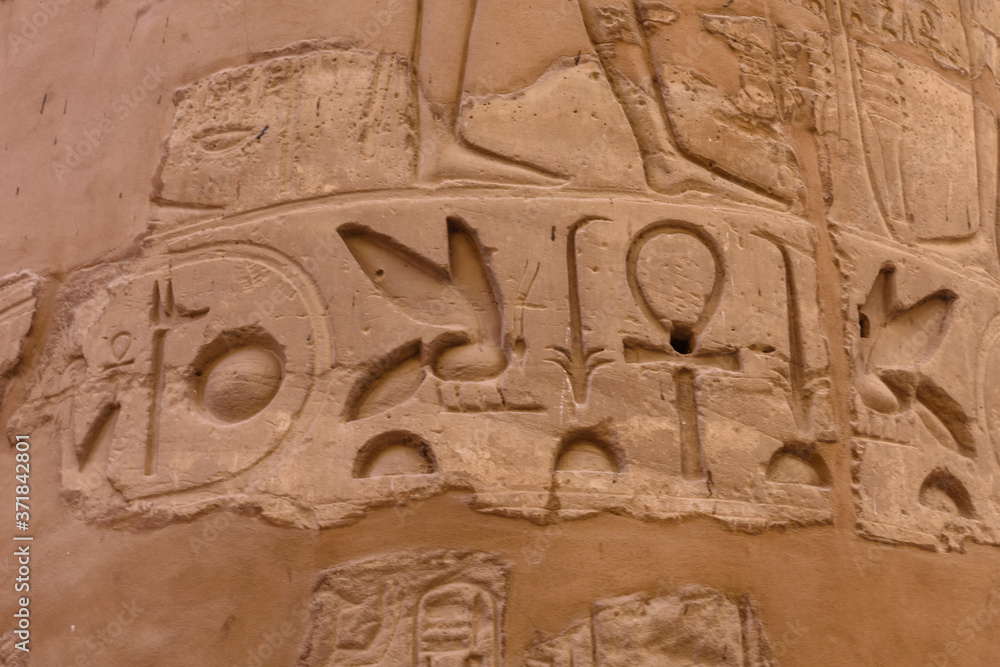Egyptian ancient hieroglyphs on the stone wall. Closeup of the symbol of eternal life ankh