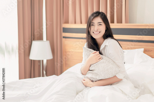 travel tourism concept of Asian beautiful woman resting waking up feeling happy smiling joyful after sleep in hotel bed comfortably relaxing sunshine morning enjoying carefree holiday accommodation © Have a nice day 
