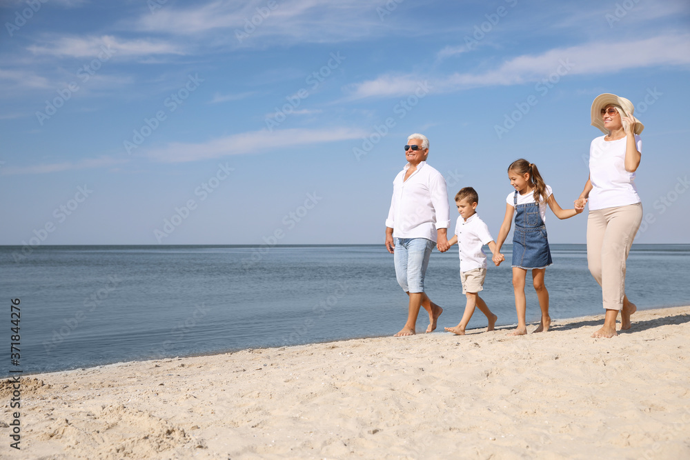 Cute little children with grandparents spending time together on sea beach Cute little children with grandparents spending time together on sea beach