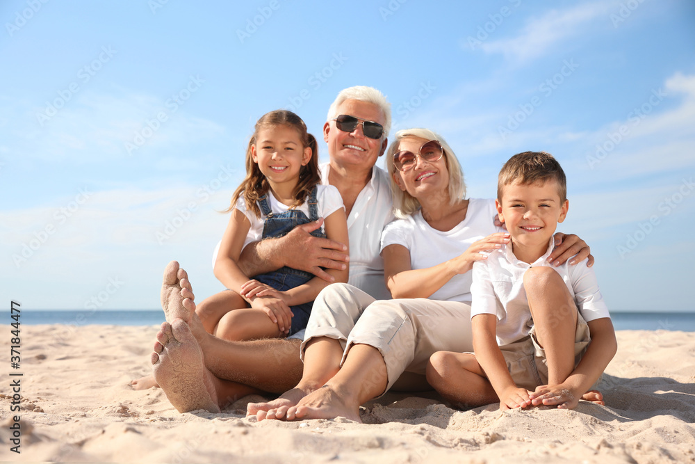 Cute little children with grandparents spending time together on sea beach Cute little children with grandparents spending time together on sea beach