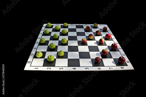 Red and green apples on the checkers Board on a black background