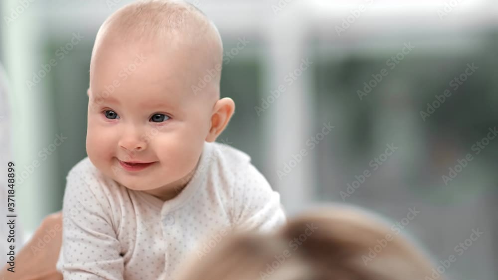 Portrait of little baby boy in pajamas sitting on mother. Medium close up shot on 4k RED camera Portrait of little baby boy in pajamas sitting on mother. Medium close up shot on 4k RED camera