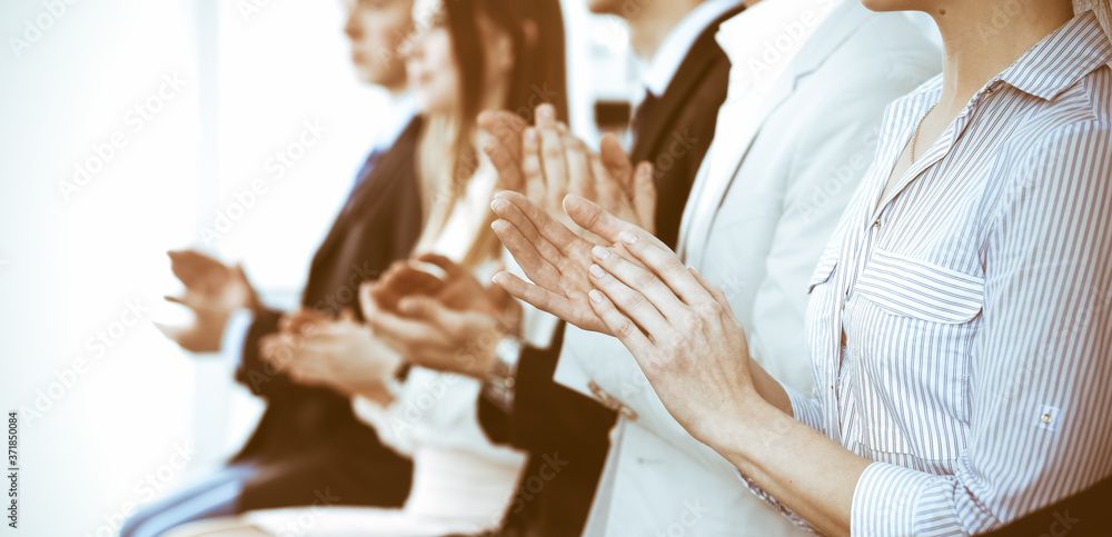 Business people clapping and applause at meeting or conference, close-up of hands. Group of unknown businessmen and women in modern white office. Success teamwork or corporate coaching concept Business people clapping and applause at meeting or conference, close-up of hands. Group of unknown businessmen and women in modern white office. Success teamwork or corporate coaching concept