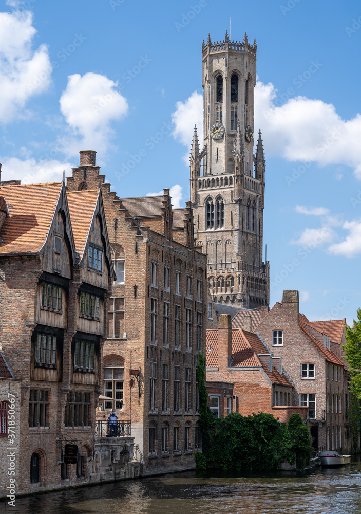 Belgium, West Flanders (Vlaanderen), Bruges (Brugge). Spire of Church of Our Lady, Onze-Lieve-Vrouwekerk behind canal.