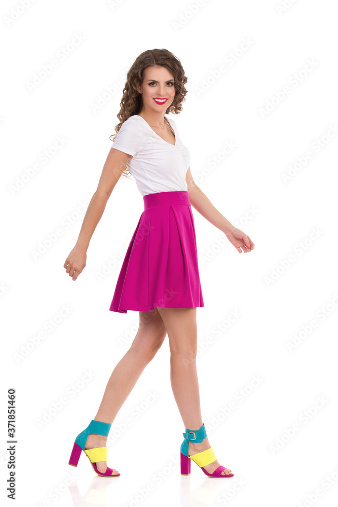 Naklejka premium Walking Young Woman In Vibrant High Heels. Side View.