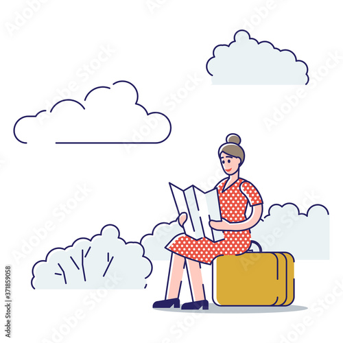 Woman sitting on roadside holding paper map and hitchhiking. Young female with suitcase hiking car