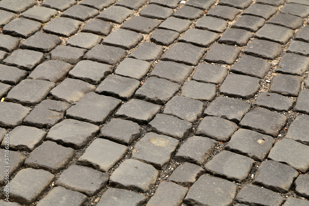 Fototapeta premium Abstract background of old cobblestone pavement close-up