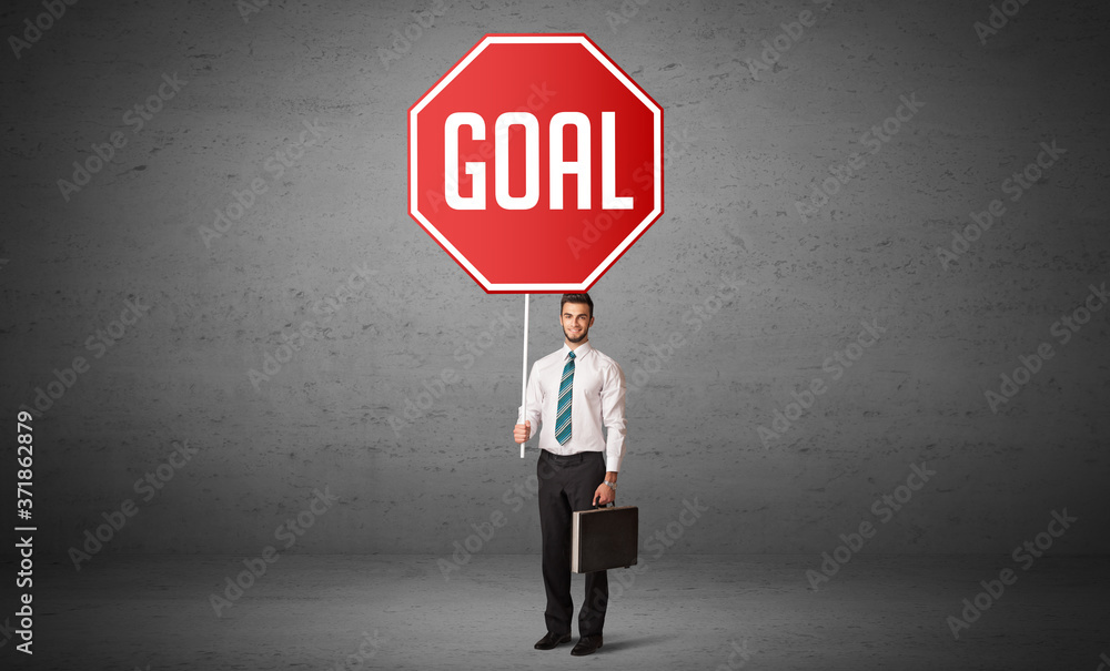 Young business person holding road sign with GOAL inscription, new rules concept Young business person holding road sign with GOAL inscription, new rules concept