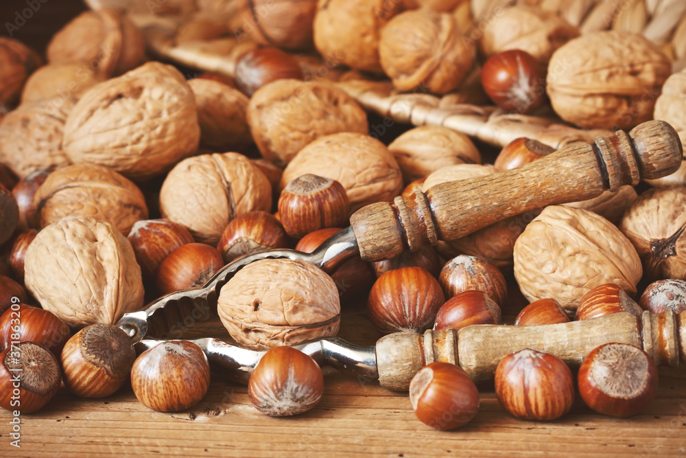 Different nuts and nutcracker on wooden table Different nuts and nutcracker on wooden table