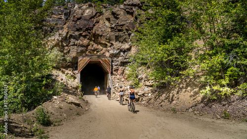 Fotografie Biking into a tunnel of the abandoned Kettle Valley Railway carved in the rocks