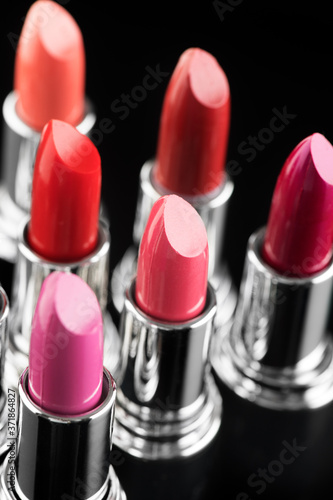 Lipstick. Fashion Colorful Lipsticks over black background. Lipstick tints palette, Professional Makeup and Beauty. Beautiful Make-up concept. Lipgloss. Vertical image