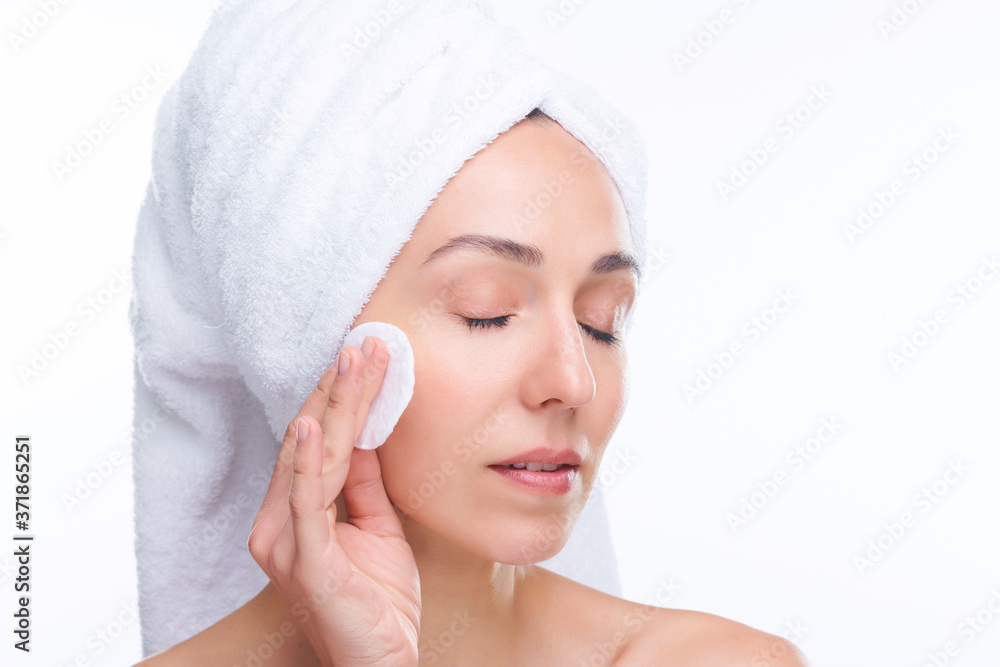 Young fresh beautiful woman with cotton pad applying purifying lotion on face Young fresh beautiful woman with cotton pad applying purifying lotion on face