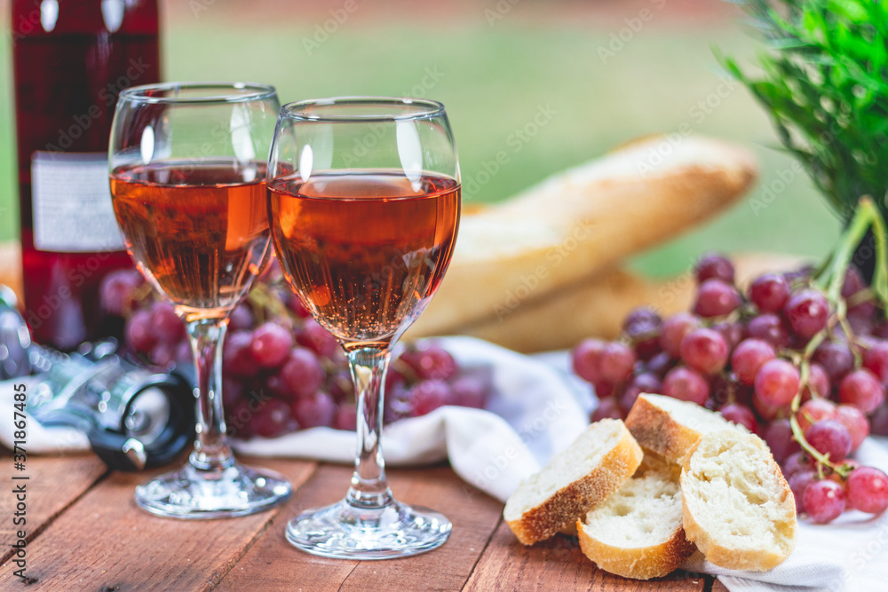Wine, Grapes, and French Bread on a Picnic Table Wine, Grapes, and French Bread on a Picnic Table