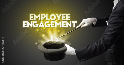 Illusionist is showing magic trick with EMPLOYEE ENGAGEMENT inscription, new business model concept