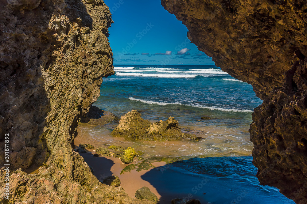A view out to sea between wave-cut boulders on Bathsheba Beach on the Atlantic coast of Barbados