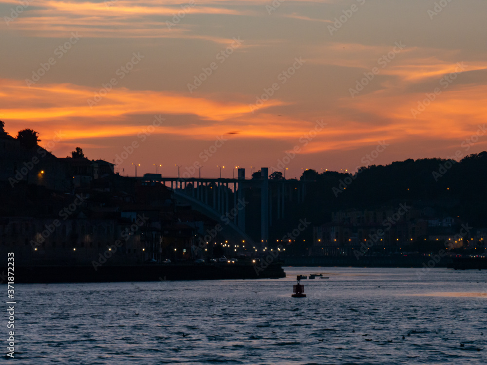 Naklejka premium Sunset at sea, with a silhouette of the coast