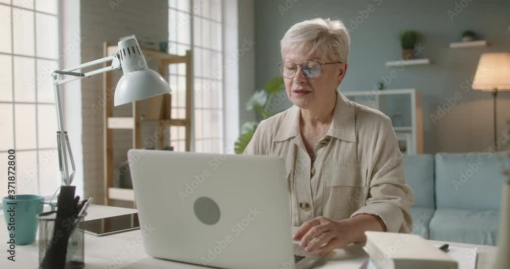 Senior caucasian lady having video chat. Experienced tutor teaching her students. Patient consulting with doctor at home using laptop 4k footage Senior caucasian lady having video chat. Experienced tutor teaching her students. Patient consulting with doctor at home using laptop 4k footage