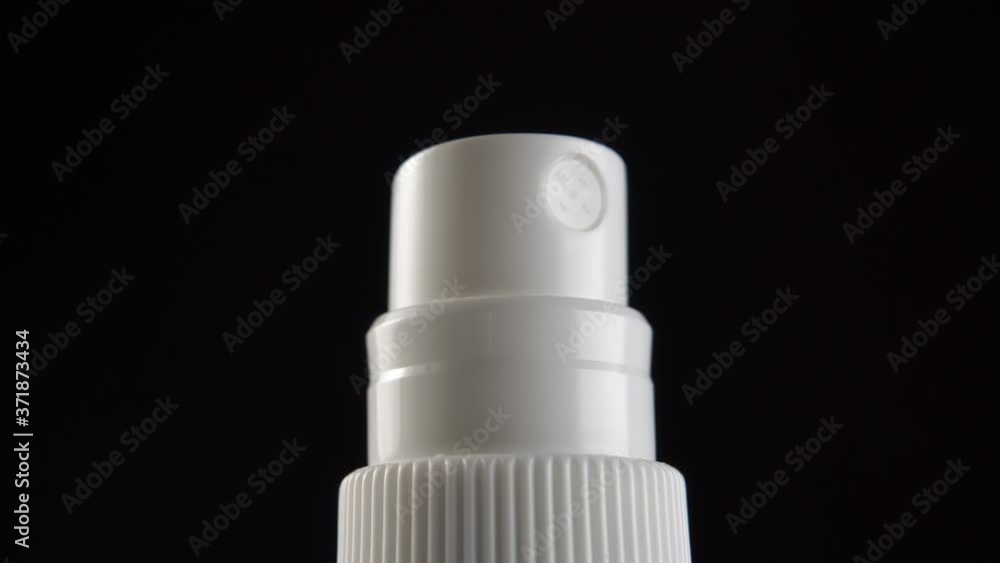 White Plastic Aerosol Hand Sanitizer Bottle. Close-up on a black background. Macro dolly shot. The concept of protection against infection and bacteria of the coronavirus COVID-19 White Plastic Aerosol Hand Sanitizer Bottle. Close-up on a black background. Macro dolly shot. The concept of protection against infection and bacteria of the coronavirus COVID-19