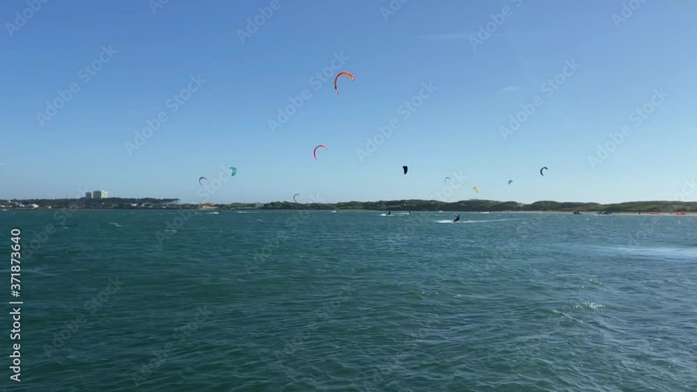 People practicing kitesurf. Kitesurfers on the mouth of the Cavado River in Esposende, Portugal. Esposende it's renowned by kite-surfers as one of the best places to kitesurf. People practicing kitesurf. Kitesurfers on the mouth of the Cavado River in Esposende, Portugal. Esposende it's renowned by kite-surfers as one of the best places to kitesurf.