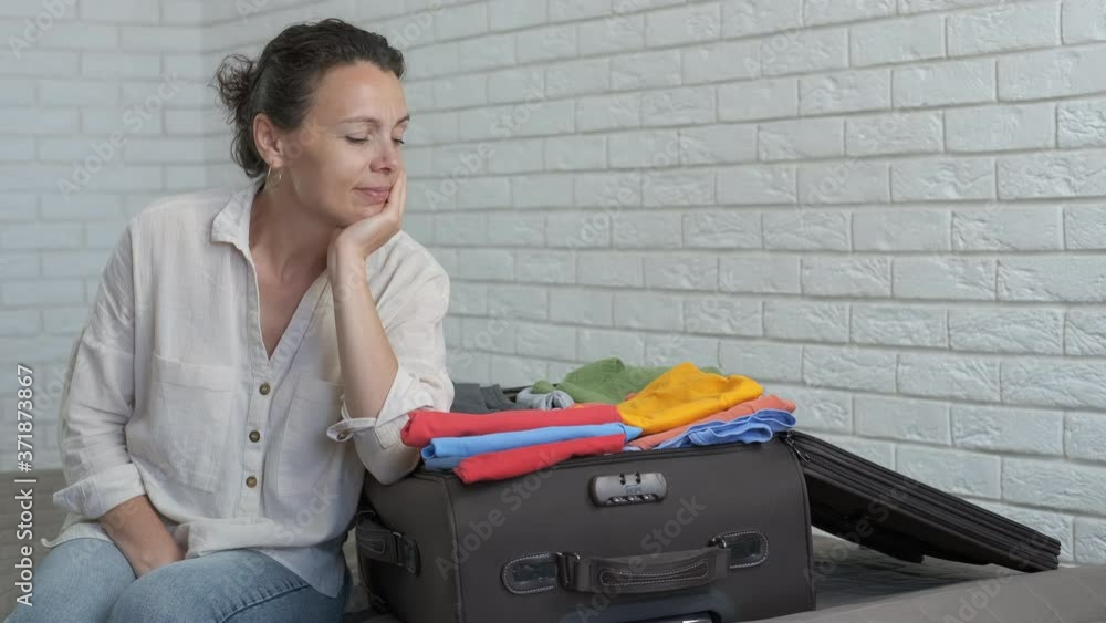 Preparing clothes for traveling. A woman with a suitcase filled with clothes in anticipation of rest. Preparing clothes for traveling. A woman with a suitcase filled with clothes in anticipation of rest.