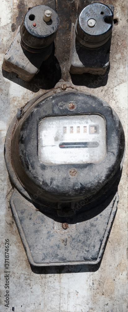 Old, dirty electricity meter and two protectors on a wooden base Old, dirty electricity meter and two protectors on a wooden base
