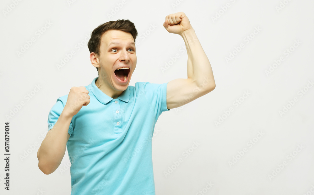 Fototapeta premium young man celebrating victory over white background