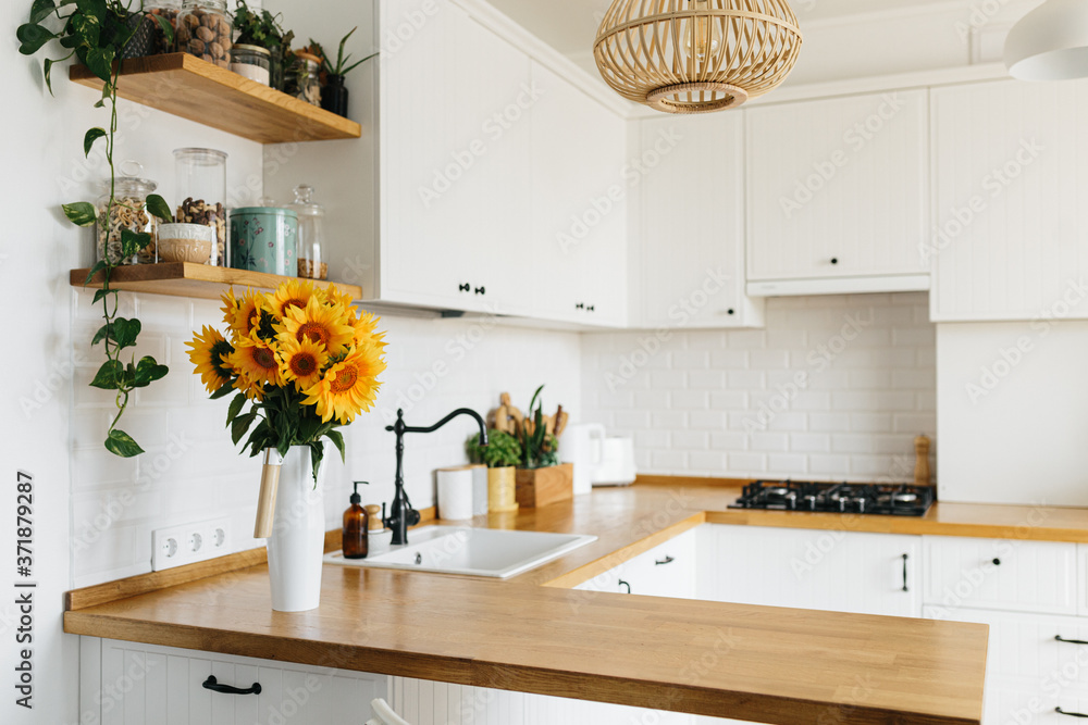 Obraz na płótnie sunflowers bouquet in vase on the kitchen. View on white simple modern kitchen in scandinavian style w salonie