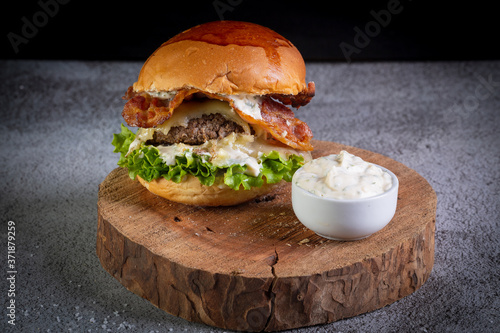 Two smash burgers with cheese, bacon, letuce and garlic sauce. Rustic craft burger. photo