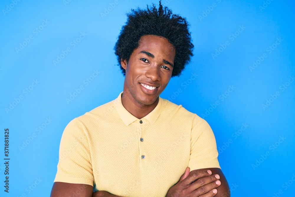 Handsome african american man with afro hair wearing casual clothes happy face smiling with crossed arms looking at the camera. positive person. Handsome african american man with afro hair wearing casual clothes happy face smiling with crossed arms looking at the camera. positive person.