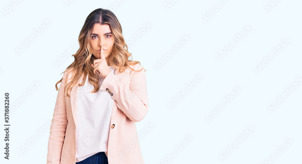 Young caucasian woman wearing business clothes asking to be quiet with finger on lips. silence and secret concept. Young caucasian woman wearing business clothes asking to be quiet with finger on lips. silence and secret concept.