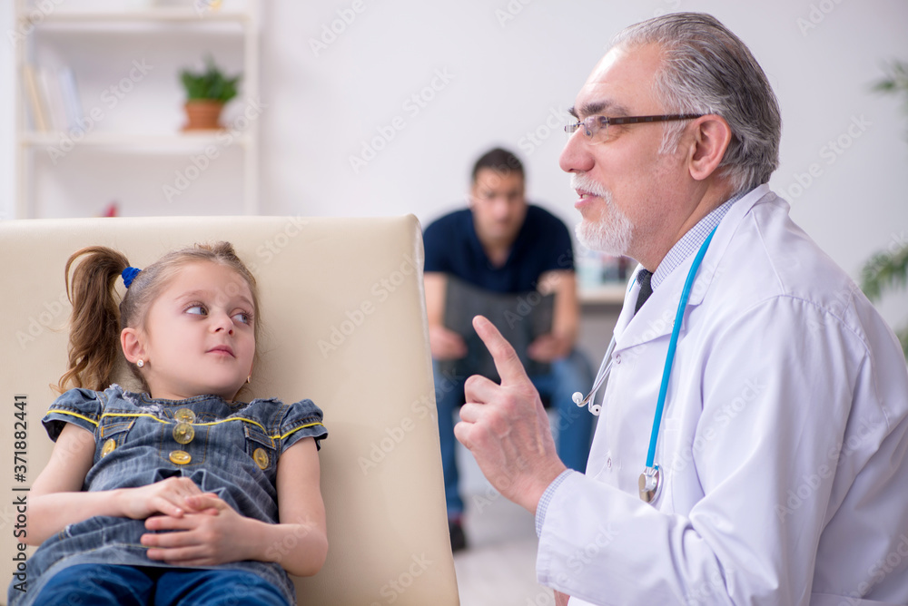 Young father and his daughter visiting old male doctor Young father and his daughter visiting old male doctor