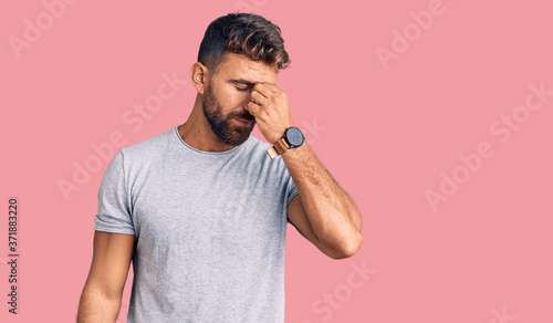 Young hispanic man wearing casual clothes tired rubbing nose and eyes feeling fatigue and headache. stress and frustration concept.