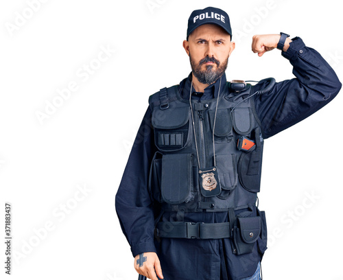 Young handsome man wearing police uniform strong person showing arm muscle, confident and proud of power
