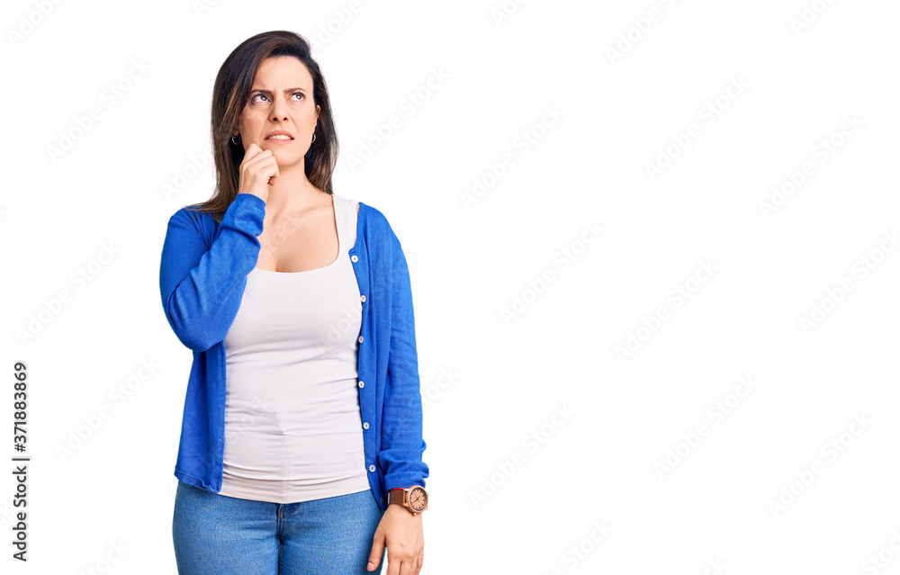 Young beautiful woman wearing casual clothes serious face thinking about question with hand on chin, thoughtful about confusing idea Young beautiful woman wearing casual clothes serious face thinking about question with hand on chin, thoughtful about confusing idea