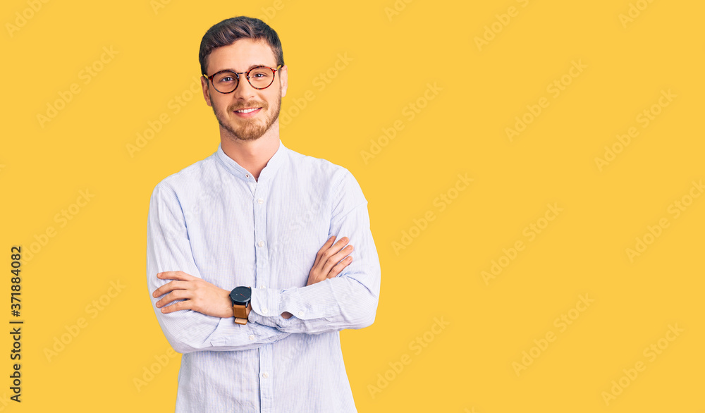 Handsome young man with bear wearing elegant business shirt and glasses happy face smiling with crossed arms looking at the camera. positive person. Handsome young man with bear wearing elegant business shirt and glasses happy face smiling with crossed arms looking at the camera. positive person.