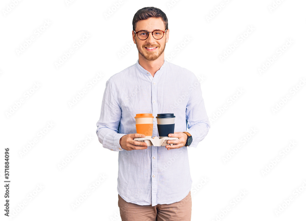 Handsome young man with bear holding takeaway cup of coffee looking positive and happy standing and smiling with a confident smile showing teeth Handsome young man with bear holding takeaway cup of coffee looking positive and happy standing and smiling with a confident smile showing teeth