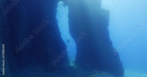 Wallpaper Mural scuba divers exploring and swimming around an arch underwater cave and tunnel swim trough ocean scenery Torontodigital.ca
