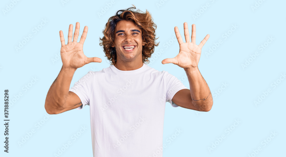 Young hispanic man wearing casual white tshirt showing and pointing up with fingers number ten while smiling confident and happy. Young hispanic man wearing casual white tshirt showing and pointing up with fingers number ten while smiling confident and happy.