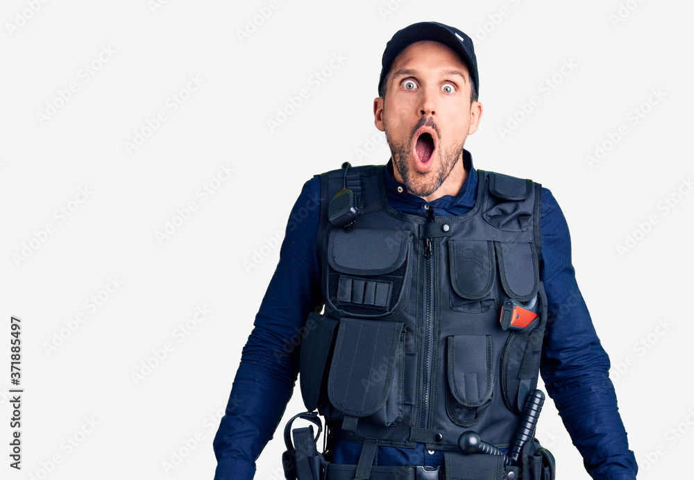 Young handsome man wearing police uniform afraid and shocked with surprise and amazed expression, fear and excited face. Young handsome man wearing police uniform afraid and shocked with surprise and amazed expression, fear and excited face.