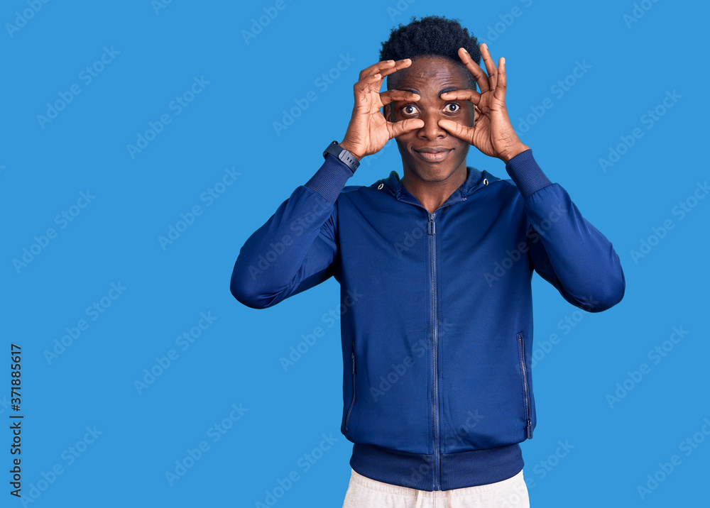Young african american man wearing sportswear trying to open eyes with fingers, sleepy and tired for morning fatigue Young african american man wearing sportswear trying to open eyes with fingers, sleepy and tired for morning fatigue