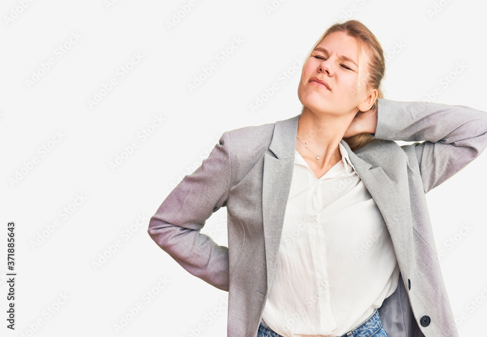 Young beautiful blonde woman wearing elegant jacket suffering of neck ache injury, touching neck with hand, muscular pain Young beautiful blonde woman wearing elegant jacket suffering of neck ache injury, touching neck with hand, muscular pain