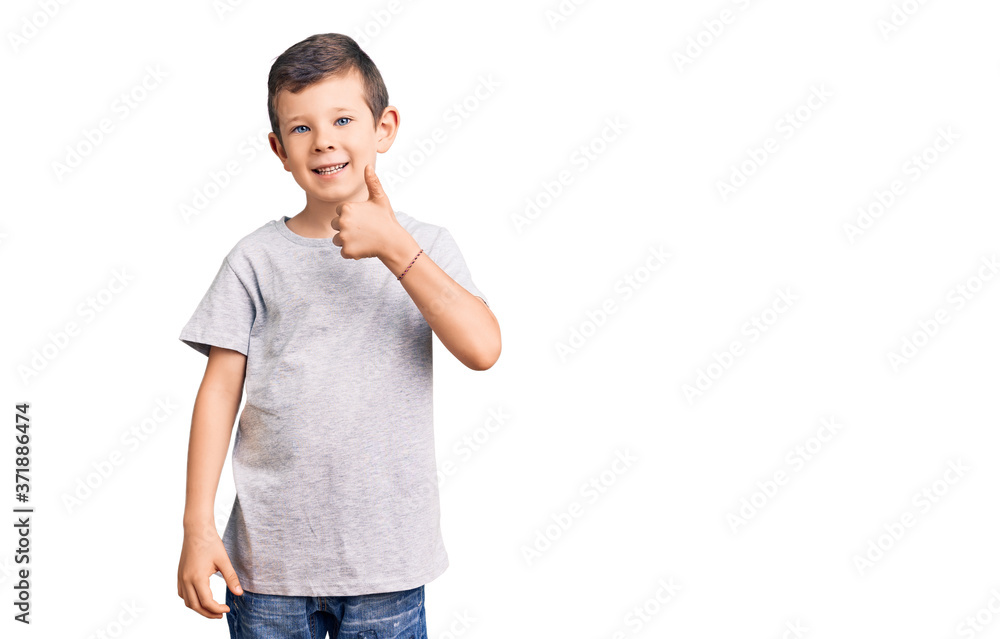 Cute blond kid wearing casual clothes smiling happy and positive, thumb up doing excellent and approval sign Cute blond kid wearing casual clothes smiling happy and positive, thumb up doing excellent and approval sign