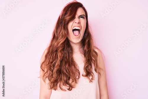 Young beautiful woman wearing casual clothes angry and mad screaming frustrated and furious  shouting with anger. rage and aggressive concept.