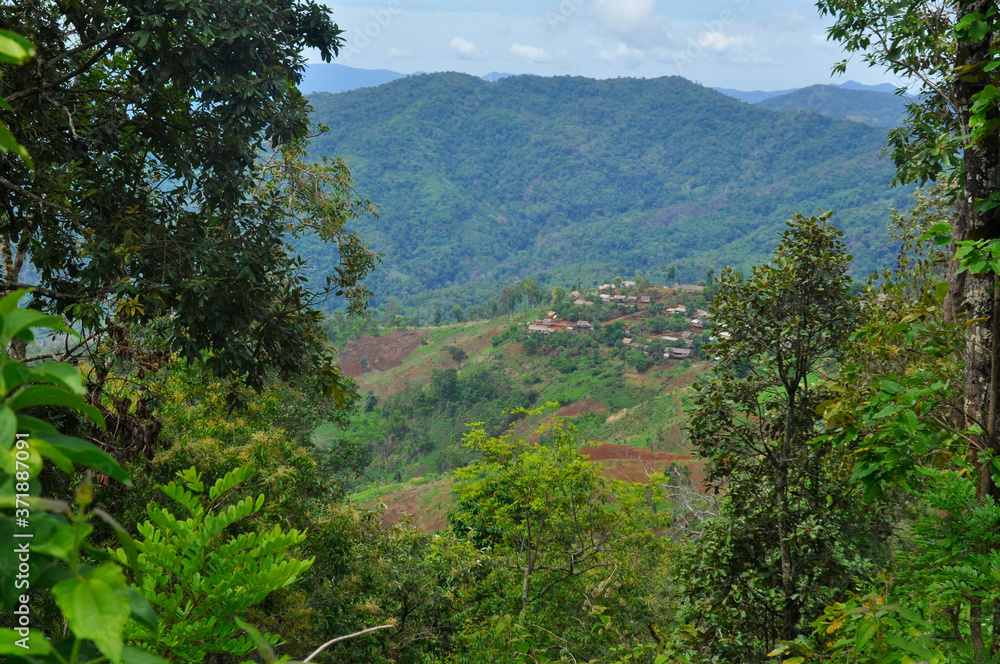 Views of expansive forest and a small village in the mountains of Thailand