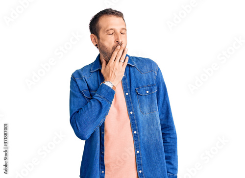 Young handsome man wearing casual clothes bored yawning tired covering mouth with hand. restless and sleepiness.