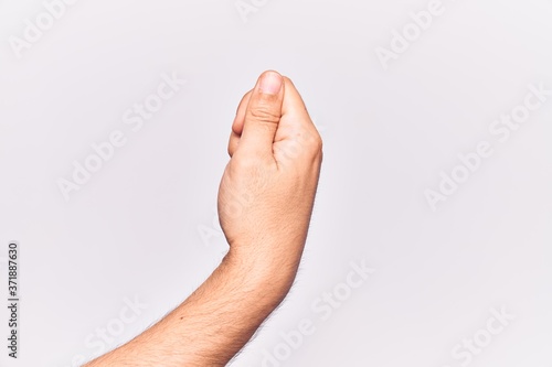 Close up of hand of young caucasian man over isolated background holding blank space with thumb finger, business and advertising