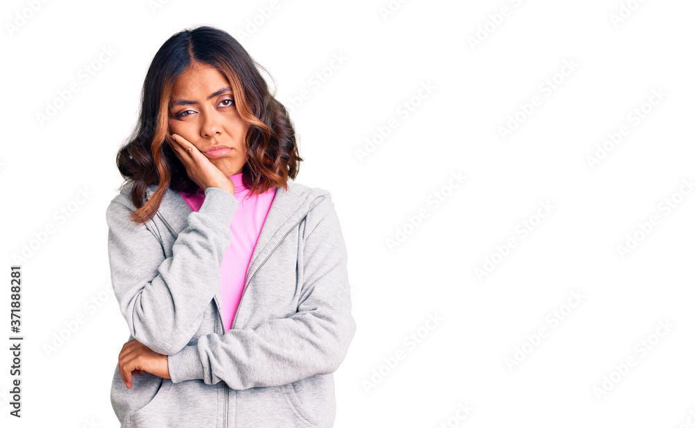 Young beautiful mixed race woman wearing casual sporty clothes thinking looking tired and bored with depression problems with crossed arms. Young beautiful mixed race woman wearing casual sporty clothes thinking looking tired and bored with depression problems with crossed arms.